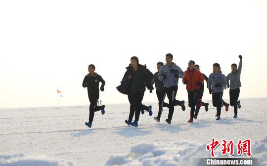 19日，800余名冰上馬拉松競(jìng)賽選手 “全副武裝”前行，他們?cè)谇Ю锉獾牟┧跪v湖面上劃出一條閃亮的軌跡。　年磊 攝