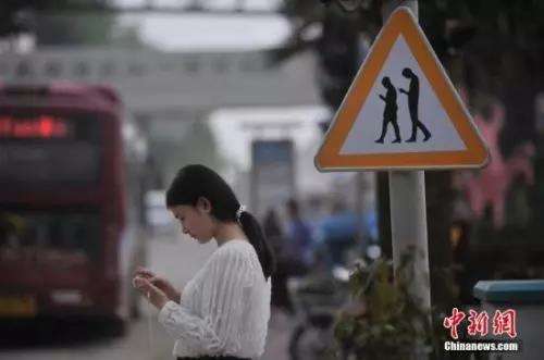 資料圖：重慶一紅綠燈處擺放“不做低頭族、關注紅綠燈”警示牌。 陳超 攝